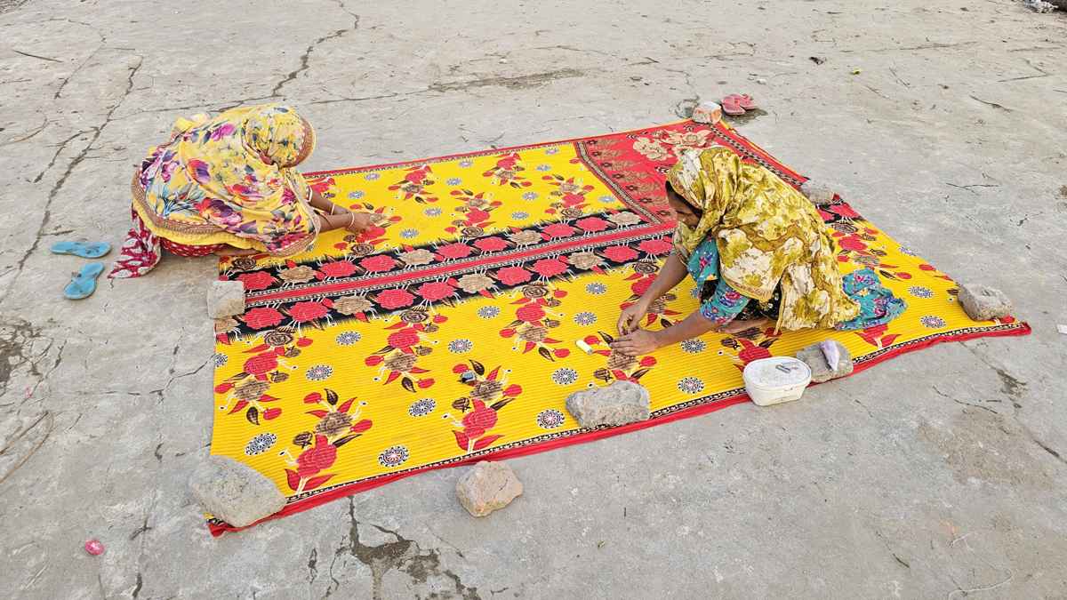 পৌষের রোদে নকশী কাঁথা সেলাইয়ে মগ্ন গ্রামের নারীরা